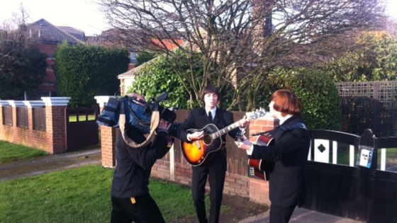 ITN Cameraman Keith Edwards films a Beatles tribute act outside the newly listed building in Liverpool