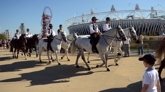 Mounted police officers ride past the Olympic stadium in the Olympic Park, during the Paralympic Games in London.