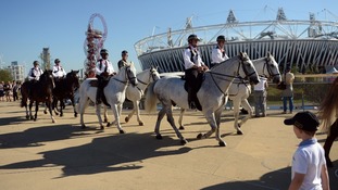 Mounted police officers ride past the Olympic stadium in the Olympic Park, during the Paralympic Games in London.