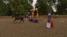 A horse races a motorbike through a flaming hoop.