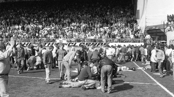 Fans on the pitch receiving attention after severe crushing at Hillsborough