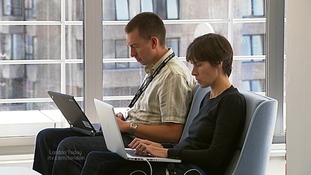 Two people typing on laptops.