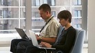 Two people typing on laptops.