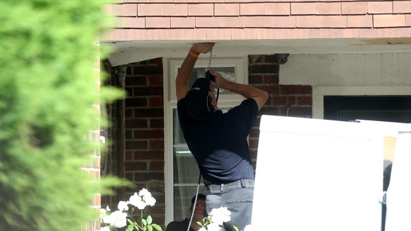 Police use a fibre optic camera as they search outside the home of Saad al-Halli in Claygate, Surrey.