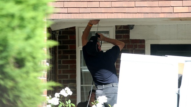 Police use a fibre optic camera as they search outside the home of Saad al-Halli in Claygate, Surrey.