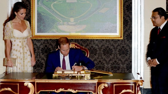 The Duke of Cambridge signs a special book at the residence of Malaysia's king.