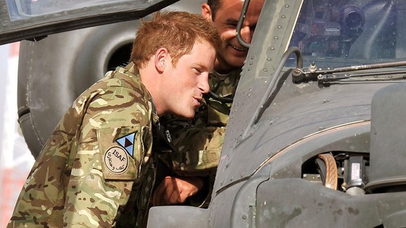 Prince Harry examines the cockpit of an Apache helicopter