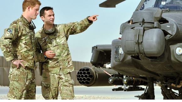 Prince Harry is shown the Apache flight-line by a member of his squadron