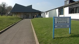 Exterior of King Edward VI Community College in Totnes with sign