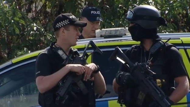 Armed police the Oxney Road travellers' site on the outskirts of Peterborough