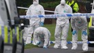 Police forensic officers search the scene of a shooting in Hattersley