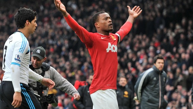 Manchester United's Patrice Evra celebrates victory as Liverpool's Luis Suarez walks off during last season's match between the sides.