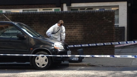 Forensic teams examine the crime scene on Byng Street, east London