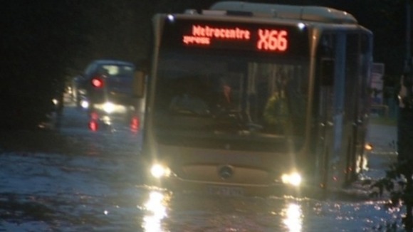 A bus is submerged in rain water in Gateshead today.