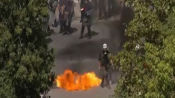 A police officer pictured avoiding a petrol bomb.