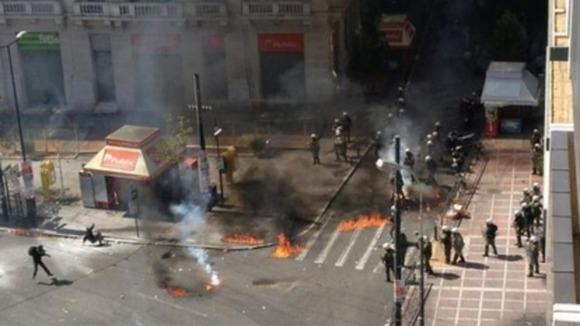 Protesters throw petrol bombs at riot police in Athens.