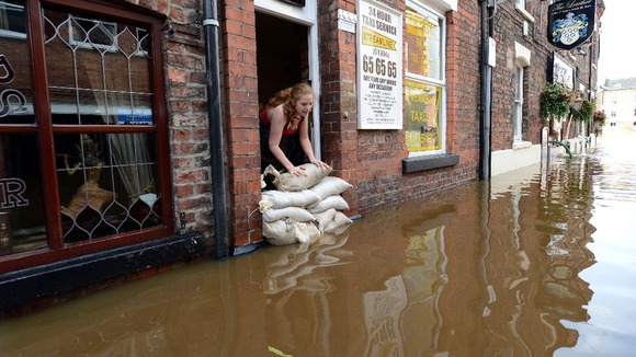 A cyclist avoids flood water on the closed A34 near Alderley Edge, Cheshire.
