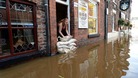A cyclist avoids flood water on the closed A34 near Alderley Edge, Cheshire.