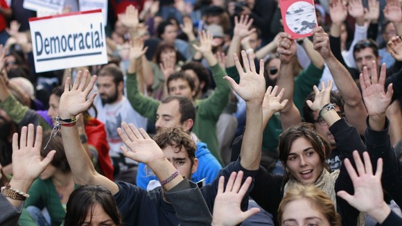 Protesters shout slogans during a demonstration outside Madrid's Parliament