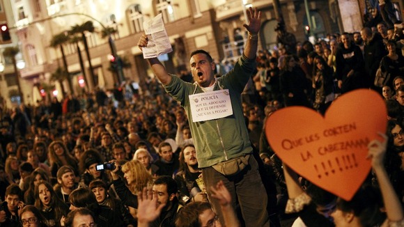 Protesters shout slogans during a demonstration outside Madrid's Parliament