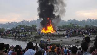 Nepalese gather around the burning wreckage at the crash