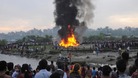 Nepalese gather around the burning wreckage at the crash