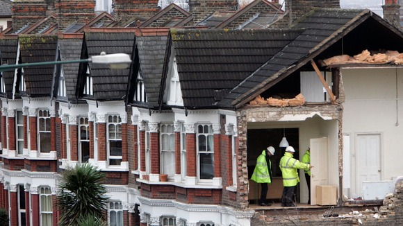Assessors look at damage to a property on Chamberlayne Road in the Kensal Rise area of north London the day after a small tornado struck.