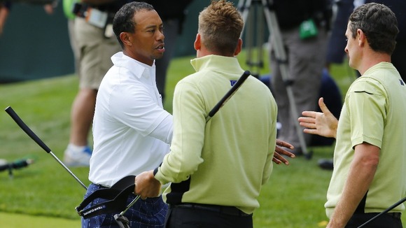 Tiger Woods shakes hands with Team Europe golfers Rose and Poulter after Team Europe won their match
