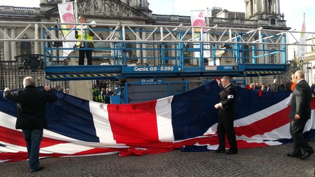 The gigantic Union Flag is hoisted by members of the Orange Order