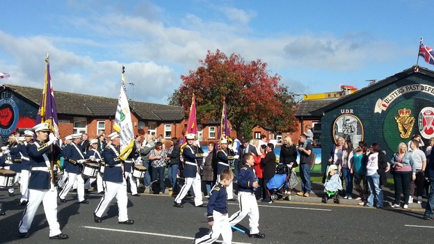 Residents of East Belfast wait for the parade to pass, in the shadow of the iconic Harland and Wolff cranes.