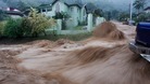 A torrent of water water rushes past a vehicle at Westvale Park, Glencoe, about 10 km (6 miles) from the capital Port-of-Spain