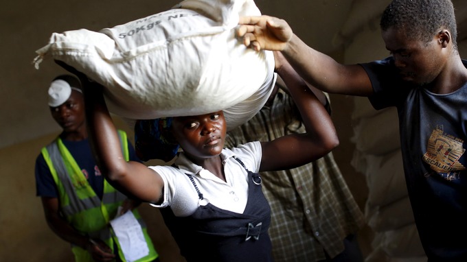 A woman carries food aid distributed by the United Nations World Food Progamme in Malawi