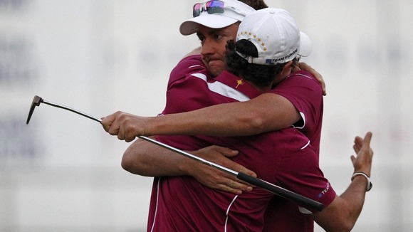 Ian Poulter hugs teammate Rory McIlroy