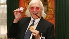 Sir Jimmy Savile after he received a commemorative badge from Prime Minister Gordon Brown at Downing Street in London for his work as a 'Bevin Boy'. 
