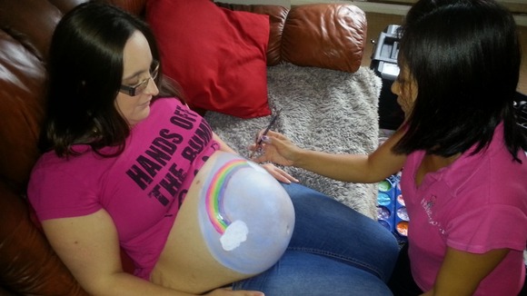 Annabelle Jones having her bump painted