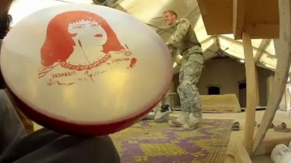 A British police officer dances to the beat of an Afghan policeman's drum