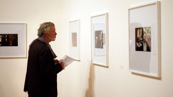 A member of the public looks at photos by Luke Fowler, who is shortlisted for the 2012 Turner prize, at Tate Britain in London.